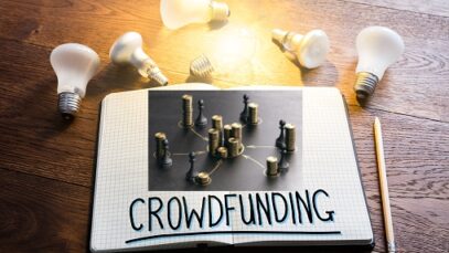 Crowdfunding Concept In Notepad Near Glowing Lightbulbs